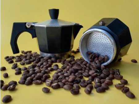 a Moka Pot with coffee beans